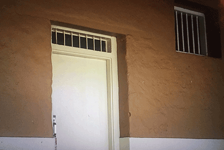 Barred windows of one of the hotel rooms at The Quod