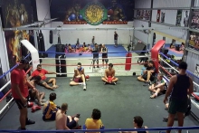 boxing-660.jpg A boxing ring with a group of young Aboriginal men seated in a circle and two older men standing