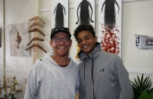 Two young men smiling to camera in an art shop