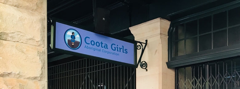 A sign outside a building. The sign says Coota Girls