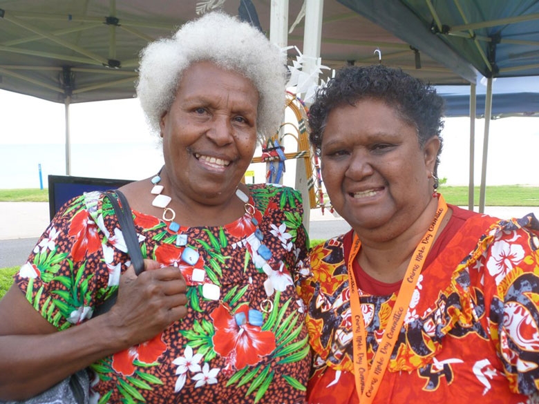 Two older women smile at the camera
