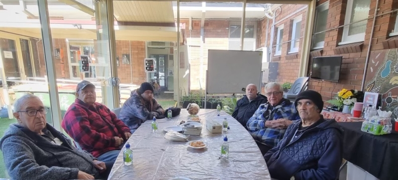 A group of men sit around a table