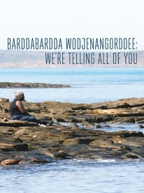 A photo of a person sitting on a rocky shore with the words Barddabardda Wodjenangordee: We’re telling all of you