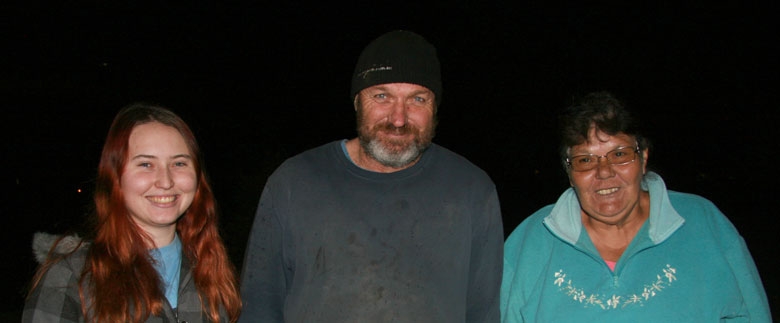 Three people smile at the camera