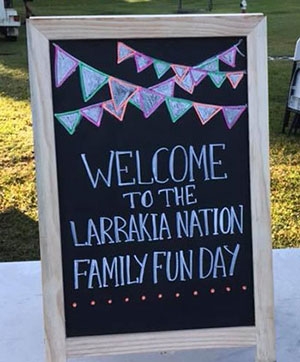 A chalkboard with the words 'Welcome to the Larrakia Nation Family Fun Day'