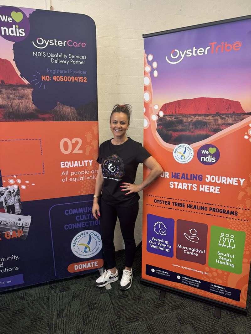 A woman poses between two large posters