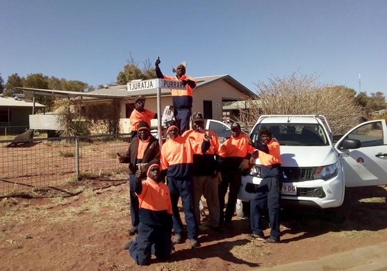 A group of people surround a street sign