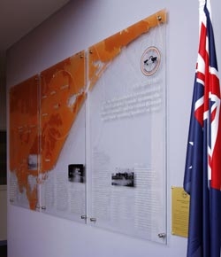 Large acrylic panels on a wall. The Australian flag is next to them