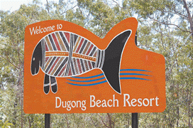 A large orange sign with the words Welcome to Dugong Beach Resort with a drawing of a dugong