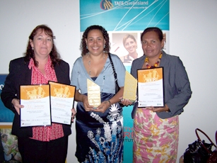Three people hold up certificates and a trophy