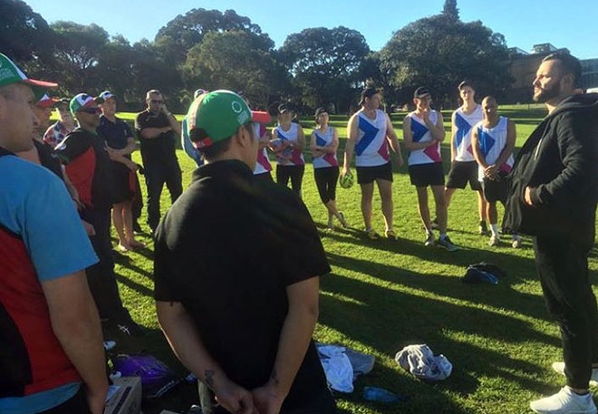 A group of players stand in a circle on a football field