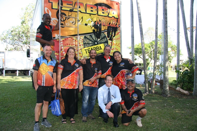 A group of people pose in front of a brightly coloured truck