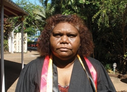A woman with a bright sash around her neck