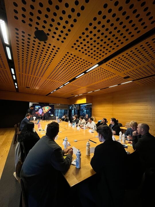 A group of people sit around a very large meeting table