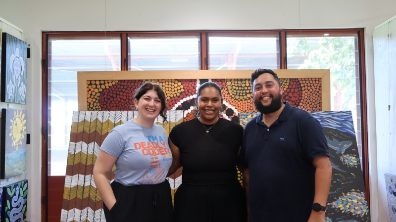 Three people smile at the camera