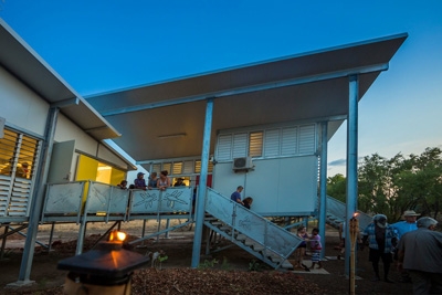 A building with images in the railings of the stairs and raised verandah