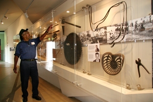A man points at an object in a glass display case