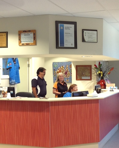 Three people behind a reception desk