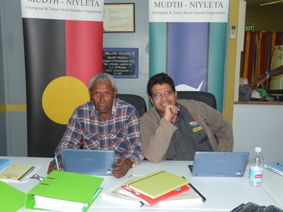 Two men sit at a desk