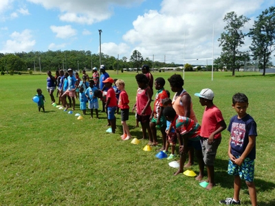 A group of children in a line on a grass oval