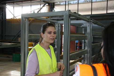 A woman in hi vis standing in a workshop