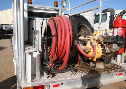 The back of a truck with a hose reel and spare tyre