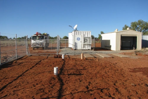 Sheds and fencing surrounded by red dirt