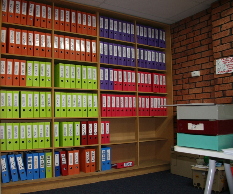 Shelves with neatly arranged coloured folders on them