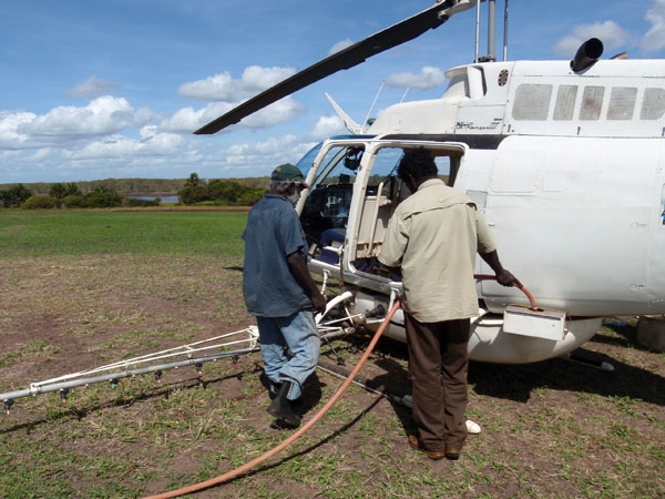 Two people refuel a helicopter