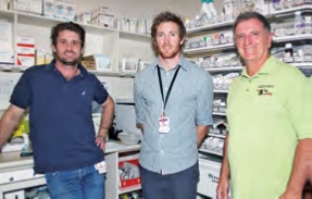 Three men stand in a pharmacy