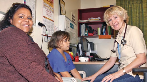 A woman and a child sit facing a doctor