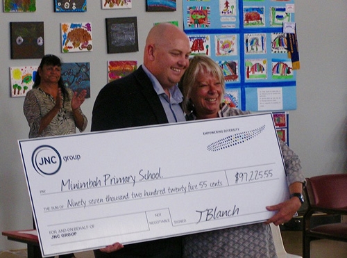 A man and woman holding a large novelty cheque